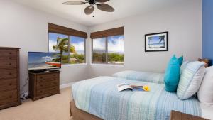 a bedroom with a bed and a tv and windows at SEASHELL VILLA Lovely 3BR Kulalani Home with Private Beach Club Bikes in Waikoloa +44 photos