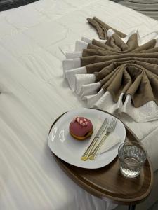 a plate with a donut on a table on a bed at Angel's Studio Apartments in Tirana