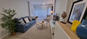 a living room with a blue couch and a tv at Salinetas apartamento junto al mar in Telde