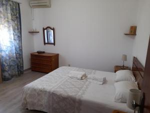 a bedroom with a large white bed with two pillows at Belamandil Garden ,family holidays ,caminho do torrejao olhao in Olhão
