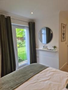 a bedroom with a window and a bed and a mirror at Fly By in Duxford