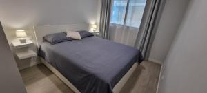 a small bed in a small room with a window at Salinetas apartamento junto al mar in Telde