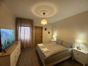 a bedroom with a bed and a flat screen tv at Casa de la Paz in Estepona