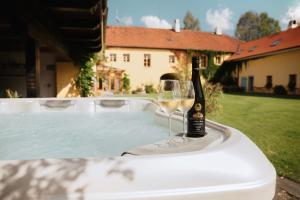 a bottle of wine and a wine glass sitting on a hot tub at Statek Zahrádka Český Krumlov in Český Krumlov