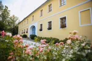 a yellow building with flowers in front of it at Statek Zahrádka Český Krumlov in Český Krumlov
