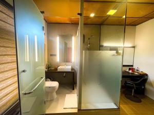 a bathroom with a toilet and a glass shower at Cruzian Bliss in Negombo