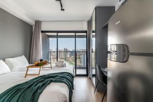 a hotel room with a bed and a balcony at NK | Vila Mariana | Localização Perfeita in São Paulo +135 photos