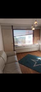 a living room with a couch and a large window at Private room in apartment near airport area vantaa in Vantaa