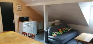 a living room with a couch and a table at Appartement mansardé et chaleureux au coeur de Cauterets in Cauterets