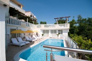 ein Balkon mit einem Swimmingpool auf einem Gebäude in der Unterkunft Villa Tenžera in Herceg-Novi