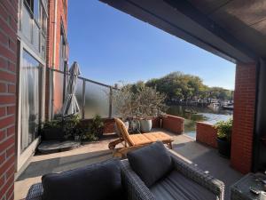a patio with a couch and a table on a balcony at Willemsbrug Vista in Schiedam