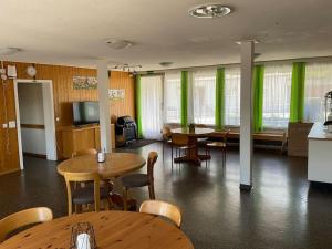 a room with tables and chairs and green curtains at 14 - Gästehaus Erika - Hundwil - Appenzellerland in Hundwil