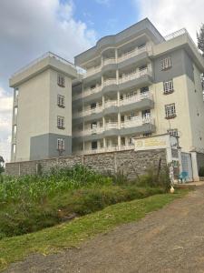 a large apartment building with a stone wall in front of it at Eldoret Executive 2 bedroom Centennial in Eldoret