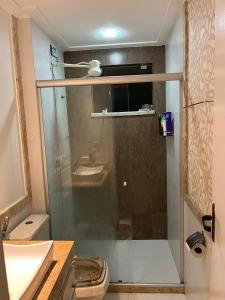 a bathroom with a shower with a toilet and a sink at Apartamento Paraiso Litoral in São Pedro da Aldeia +16 photos