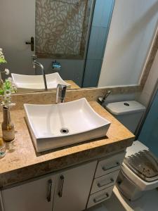 a bathroom with a sink and a toilet at Apartamento Paraiso Litoral in São Pedro da Aldeia