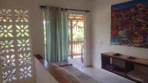 a living room with a sliding glass door to a patio at Souzas House in Vera Cruz de Itaparica