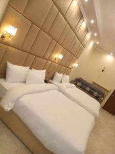a bedroom with two beds with white pillows at Hotel Elegant Near Karachi Expo Center and Agha Khan in Karachi