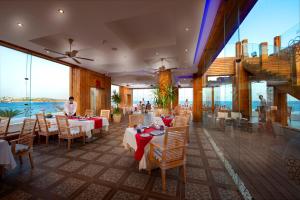a restaurant with tables and chairs with a view of the ocean at Sunrise Arabian Beach Resort in Sharm El Sheikh