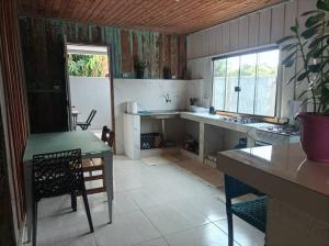 a kitchen with a counter and a table and a table and chairs at Casa aconchegante no centro in Bonito