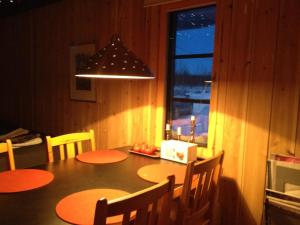 una sala da pranzo con tavolo, sedie e finestra di Kaamasmukka 77 a Koikkiniva