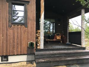 una veranda in legno di una cabina con panchina di Kaamasmukka 77 a Koikkiniva