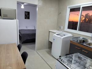 Una pequeña cocina con fregadero y refrigerador. en Stúdio Aconchegante, en Santa Maria