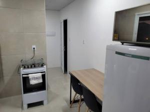 una pequeña cocina con fogones y mesa de madera. en Stúdio Aconchegante, en Santa Maria 14 fotos más