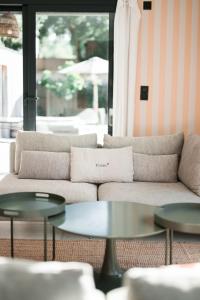a living room with a couch and two tables at Villa Contis Plage in Lit-et-Mixe
