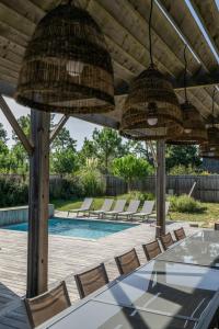 a patio with a table and chairs and a pool at Villa Contis Plage in Lit-et-Mixe