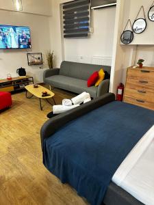 una sala de estar con una cama y un sofá en NEW COZY home ATHENS heart KYPSELI !, en Atenas