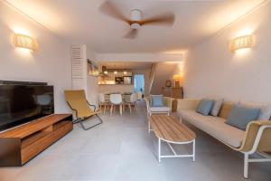 a living room with a couch and a tv at Maison de Vacances Tiffany Blue in Grand Baie