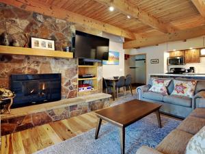 a living room with a large stone fireplace at Timberline Condominiums 1 Bedroom Deluxe Unit B1C in Snowmass Village
