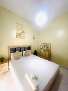 Un dormitorio con una gran cama blanca con toallas. en Darna tangier, en Tánger