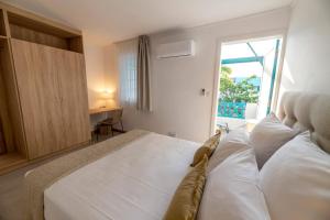 a bedroom with a white bed and a window at Maison de Vacances Tiffany Blue in Grand Baie +43 photos