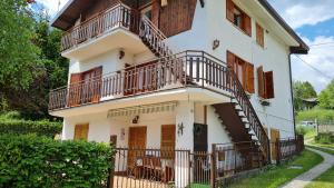 a white house with a staircase on it at Appartamento Acero Rosso in Borno