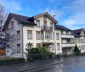 a large white house with a black fence at 18 - Gästehaus Erika - Hundwil - Appenzellerland in Hundwil
