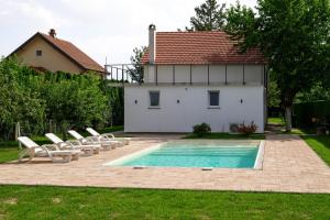 a swimming pool with lounge chairs and a house at One24 House in Čortanovci