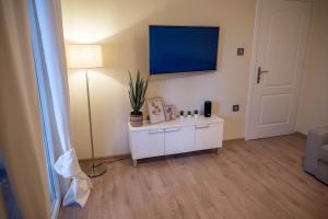 a living room with a white table and a tv at One24 House in Čortanovci