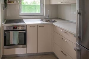 a kitchen with white cabinets and a sink at One24 House in Čortanovci