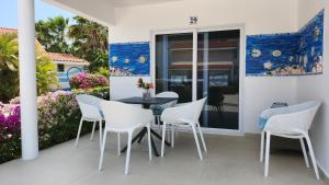 a patio with a table and chairs on a balcony at Ocean Teal Villa Marazul in Westpunt