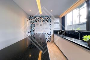 a kitchen with black countertops and a mosaic wall at Zainalofts7Vila Mariana ao lado metrô, CASV 66/102/103 in Sao Paulo