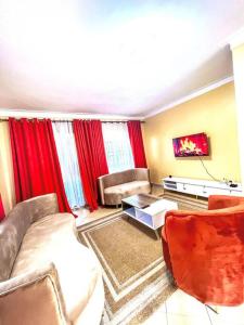 a living room with a couch and red curtains at Nappers Secrets in Kampala