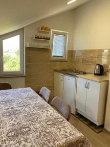 a kitchen with a table and chairs in a room at Apartmani Sara Trebinje in Zasad
