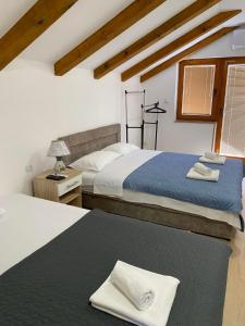 a bedroom with two beds and a table with a lamp at Apartmani Sara Trebinje in Zasad