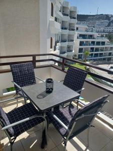 un tavolo e delle sedie sul balcone di un palazzo di Apartamento en Puerto Rico,Mogan a Puerto Rico de Gran Canaria