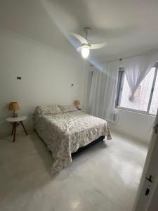 Un dormitorio blanco con una cama y una ventana. en Apt 72, en Santos