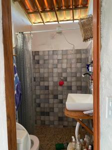 un bagno con lavandino, doccia e WC di casa arandu a Amontada