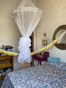 una camera da letto con un letto con zanzariera di casa arandu a Amontada