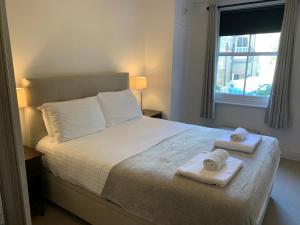 a bedroom with a bed with two towels on it at Lovely newly refurbished apartment in Battersea in London +18 photos