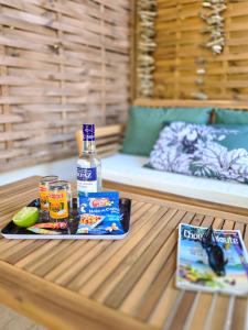 a table with a bottle of alcohol and a book at Villa Ti Kay Paradi - Accès plage direct in Saint-Pierre +38 photos